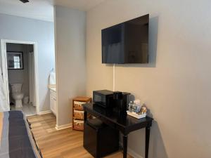 a room with a bed and a television on a wall at The Suite at 125 Royal Postes Rd in Sunset Beach