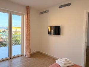 Habitación con TV en la pared y ventana en The Villas - Guest Houses, en Scafati