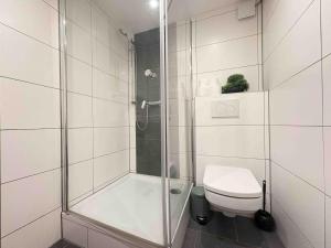 a white bathroom with a shower and a toilet at STB116 smarte Monteurwohnung in Steinberg
