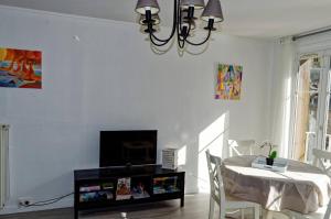 een eetkamer met een tafel en een kroonluchter bij Les Cerfs Volants 2 à 4 pers in Dieppe