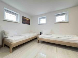 two beds in a room with two windows at STB116 smarte Monteurwohnung in Steinberg