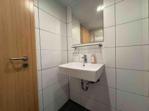 a white bathroom with a sink and a mirror at STB116 smarte Monteurwohnung in Steinberg