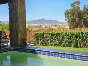 a swimming pool in a yard with a fence at The Homestead at Koringberg Country Cottages in Koringberg