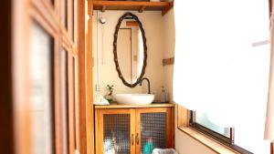 un baño con lavabo y espejo en Guesthouse Azumaya, en Matsumoto 32 fotos más