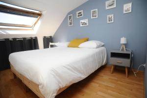 een slaapkamer met een groot wit bed en een blauwe muur bij Le Champlain Duplex Port de plaisance in Dieppe