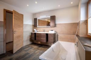 a bathroom with a tub and a sink and a mirror at Mount Apart in Zell am Ziller +14 photos