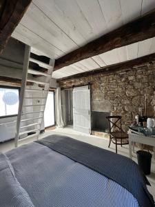 Un dormitorio con una cama y una pared de piedra. en Ca Jurzot, en Gorzegno