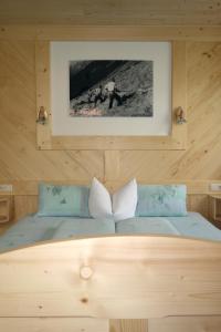 una camera con un letto con una foto sul muro di Ferienhaus Tirolerhof a Kals am Grossglockner