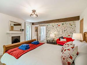 - une chambre avec un grand lit et un canapé rouge dans l'établissement 4 Bed in Winfrith Newburgh 86025, à Winfrith Newburgh