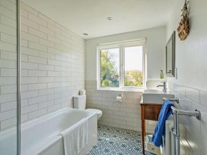 une salle de bain blanche avec une baignoire et un lavabo dans l'établissement 4 Bed in Winfrith Newburgh 86025, à Winfrith Newburgh 28 autres photos