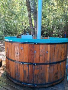 a wooden barrel with a hot tub in the woods at Cabaña con tinaja para 6 personas in San Clemente