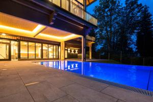 a swimming pool in front of a house at night at Hotel Klugbauer in Sommereben