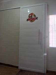 a white door with a sign on it in a room at Natal em Garanhuns, PE - Apartamento minimalista próximo ao Centro in Garanhuns