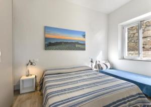 En eller flere senge i et værelse på Trilocale Giglio - vista sul mare e sui tramonti