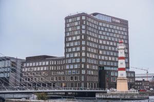 a tall building with a lighthouse in front of a building at STORY HOTEL MALMO, in JdV by Hyatt in Malmö