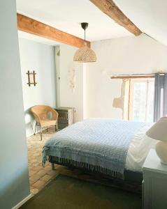 1 dormitorio con 1 cama y 1 cruz en la pared en Country House With Swimming Pool In Morvan, en Lucenay-lʼÉvêque