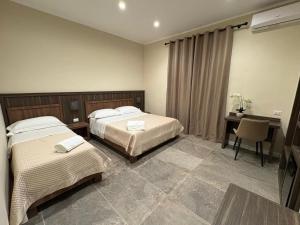 a bedroom with two beds and a desk and a table at Andrea House in Naples +12 photos