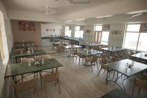 an empty dining room with tables and chairs at Shri Thakur Ji Niketan Near ISKCON Vrindavan in Vrindāvan