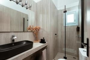 a bathroom with a black sink and a mirror at Kyma Sunset Suite w Prvate Jacuzzi in Paros National Airport