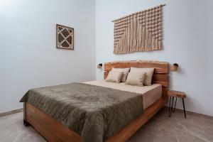 a bedroom with a bed with a wooden headboard at Kyma Paros Apartments 2 