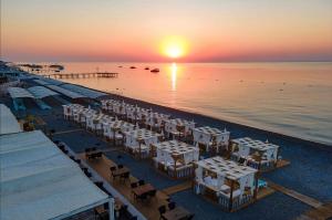 a group of tables and chairs on the beach at sunset at Club Marco Polo - Premium All Inclusive in Kemer +38 photos