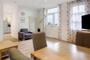 un soggiorno con tavolo da pranzo e televisione di Jogis Ferienwohnungen a Friburgo in Brisgovia