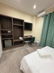 a bedroom with a bed and a desk and a television at Andrea House in Naples