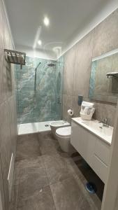 a bathroom with a toilet and a sink and a shower at Andrea House in Naples