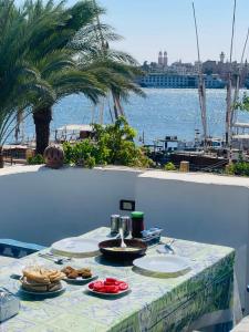einen Tisch mit Nahrung und Blick auf das Wasser in der Unterkunft Gîte Hôtel Ramla Louxor in Luxor