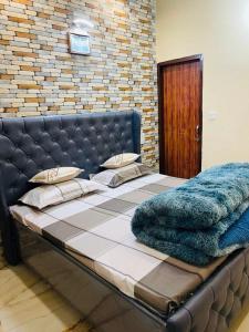 a large bed with a blue blanket on top of it at The Healing Haven in Kharar