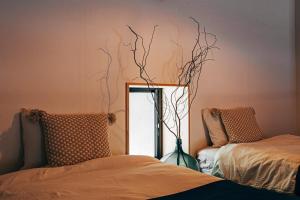 Zimmer mit einem Spiegel und einer Vase mit Ästen in der Unterkunft Ooka Tsuji - tsuji-oooka - - Vacation STAY 01156v in Chikuma