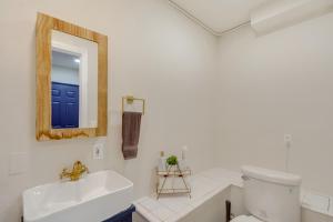 a bathroom with a sink and a toilet and a mirror at The Maharaja Retreat with Hot Tub and EV Charger! in Yucca Valley +36 photos