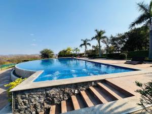 a large swimming pool in a resort with palm trees at Casa en Cuautla, Morelos 