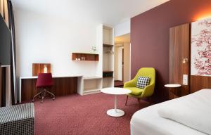 a hotel room with a bed and a table and chairs at Das Karl in Ingelheim am Rhein