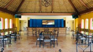 a dining room with tables and chairs and a large screen at Casa en Cuautla, Morelos 