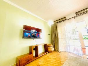 a living room with a flat screen tv on the wall at Marama Stays in Kampala