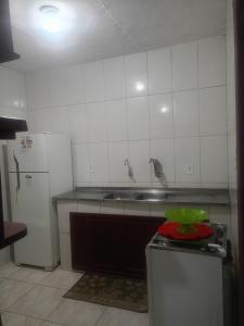 une cuisine avec un évier et un réfrigérateur dans l'établissement Hospedaria da Gabi, à São Pedro da Aldeia