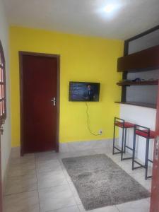 Cette chambre dispose d'une porte et d'un mur jaune. dans l'établissement Hospedaria da Gabi, à São Pedro da Aldeia