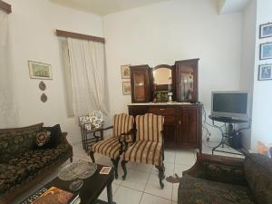 a living room with a couch and a tv at Characterful 2-Bed Home in Peaceful Town Near Agios Nikolaos in Neápolis