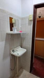 a white bathroom with a sink and a mirror at Hospedaje La Casona de los Paredones in Charbonier