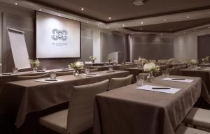a conference room with tables and chairs and a screen at The Excelsior - Small Luxury Hotels of the World in Thessaloniki