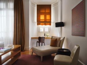 a living room with a chair and a table at The Excelsior - Small Luxury Hotels of the World in Thessaloniki