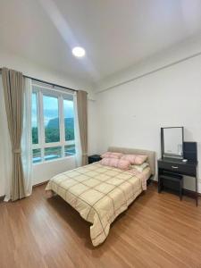 a bedroom with a bed and a desk and a window at Jhomestay2 in Sandakan +11 photos