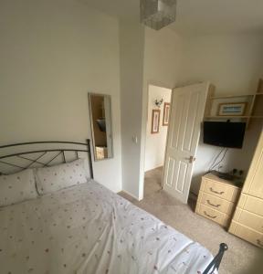 a bedroom with a white bed and a television at Kingfisher Cosy Lakeside Lodge in Carnforth +17 photos
