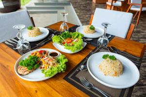 Mazarine Surf Suites- Hiriketiya في Nilwella: طاولة خشبية عليها أطباق طعام +8 صور