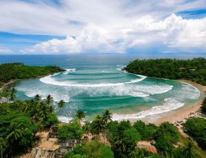 Mazarine Surf Suites- Hiriketiya في Nilwella: اطلالة جوية على شاطئ في المحيط