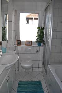 a bathroom with a toilet and a sink and a window at Punkrock Harbour Pension Bähr in Karlsruhe +17 photos