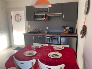 una cocina con una mesa con un mantel rojo. en Gites au jardin, en Morsbronn-les-Bains