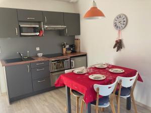 cocina con mesa y mantel rojo en Gites au jardin, en Morsbronn-les-Bains