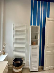 einen weißen Kühlschrank in einem Zimmer mit blauen Streifen in der Unterkunft Le Magnolia Maison 12 Couchages in Dieppe